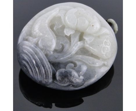A Chinese relief carved jade pendant,
with design of carp and lotus flowers, height excluding loop 2.5".