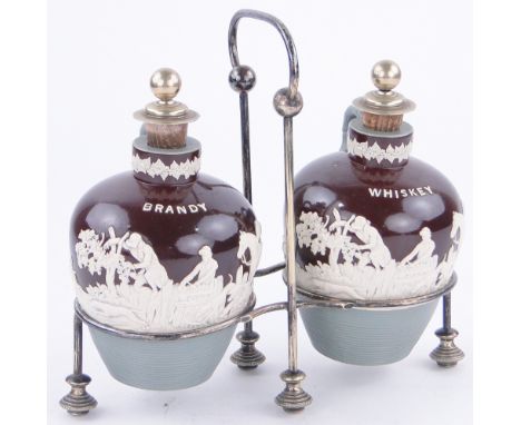A pair of Doulton Pottery decanters,
with hunting scenes, with plated stoppers, in plated stand, height 9.25" overall.