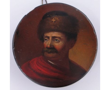 A 19th century Russian papier maché snuff box of circular form,
the lid having a hand painted design of a man wearing a fur h