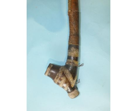 A South Sudanese Shilluk pipe, the pottery bowl with bands of cross-hatching heightened in white, leather-bound hollow wood s