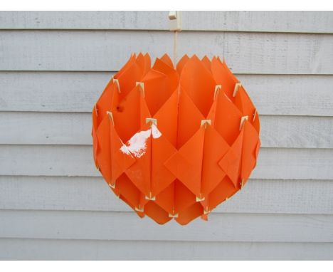A ceiling light pendant with orange plastic interlocking shade 