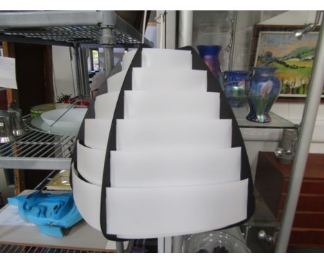 A ceiling light of black and white plastic banding 