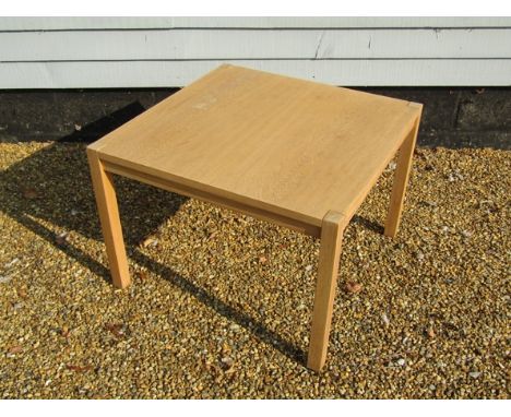 A light oak coffee table, square top, raised on square legs, 75cm x 52cm high