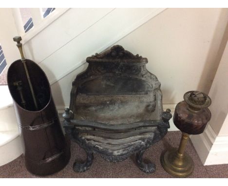 A fire pit with fireside set and purple glass paraffin lamp.