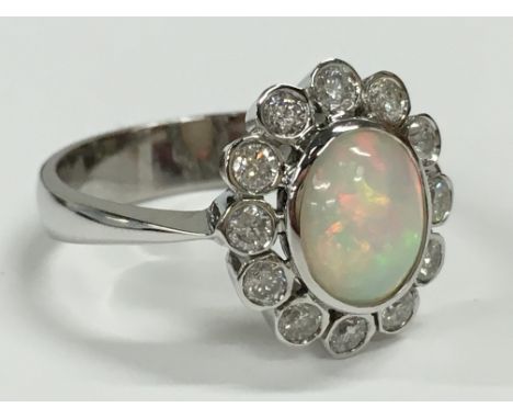 An opal and diamond set cluster ring in 18 carat white gold