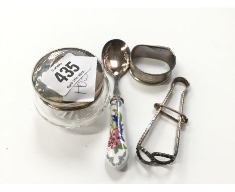 A silver topped hair tidy, a silver plated skirt lifter, a jam spoon and a silver napkin ring.