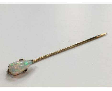 A yellow metal opal set stick pin.