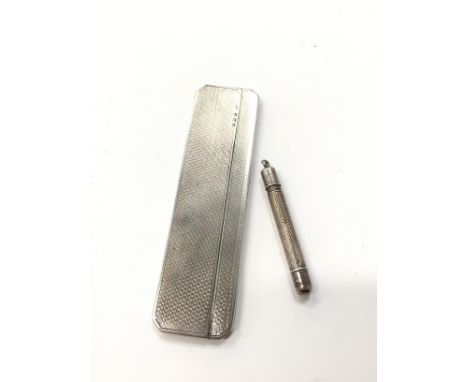 A silver folding comb together with a similar pencil.