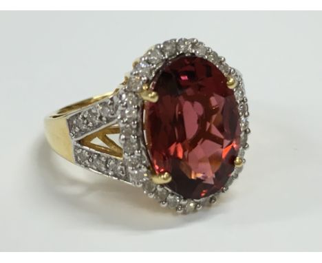 A large maroon pink tourmaline and diamond 18 carat yellow gold ring with diamond shoulders.
(R3)