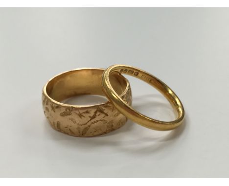 An 18 carat gold band with engraved decoration (6g) together with a 22 carat gold wedding ring (2.7g)