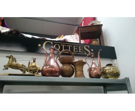A shelf containing a large quantity of various Eastern and other brass and copper items.