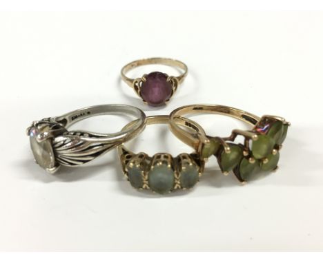 Two 9 carat gold dress rings set with green stones, together with a 9ct gold ring set with an amethyst and a silver set ring 