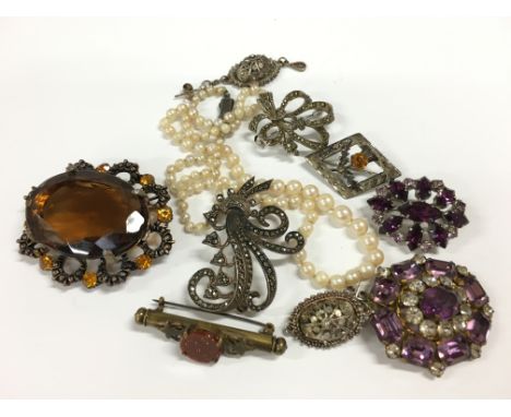 A bag of various costume jewellery to include an amethyst brooch, citrine style brooch, pearl necklace, small items of silver