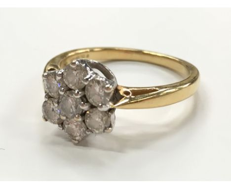 An 18 carat gold seven stone diamond cluster ring.