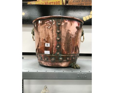 A late 19th centruy banded and riveted log bucket with brass lion ring handles resting on pad lion feet