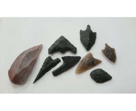 A quantity of flint arrow heads and a scraper.