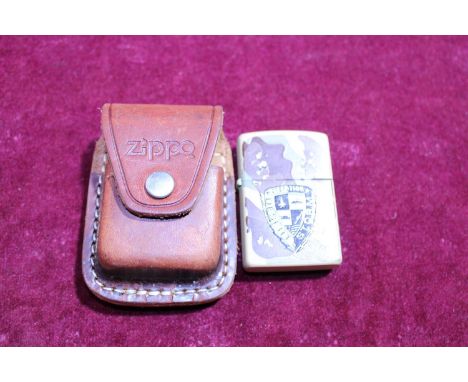 A brass Zippo lighter with leather pouch 