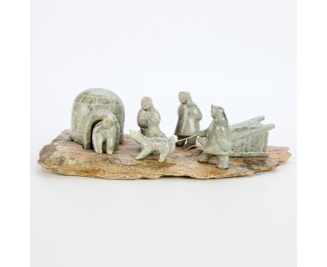 J. Ayck carved stone igloo scene comprised of a carved igloo with a figure emerging, two standing figures, and one figure hol
