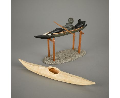 Johnassie Mannuk (Inuit (Sanikiluaq / Belcher Islands), b. 1939). A stone sculpture of a kayak with a removeable seated hunte
