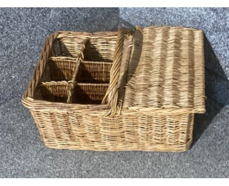 A vintage wicker picnic basket with bottle holders
