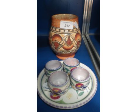 A Charlotte Rhead pottery vase and a Poole pottery egg cup and saucer set (2) 