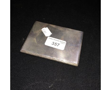 A silver cigarette case with all over engine-turned decoration and gilt interior