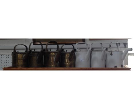 A collection of early 20th century brass and enamel hot water jugs