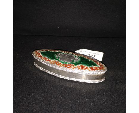 A silver and enamel dressing table box of elongated oval form, with green and red enamels