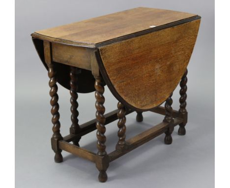 A 1930’s oak oval gate-leg dining table on barley-twist legs &amp; turned feet with plain stretchers, 36” x 48”.