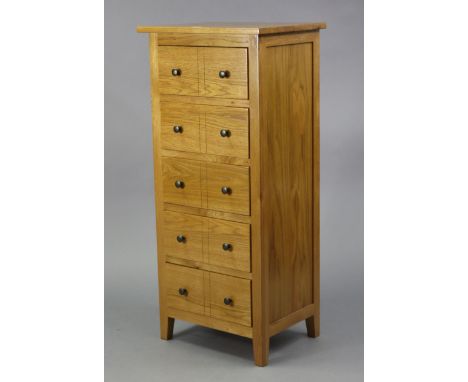 A modern light oak small upright chest fitted five long drawers, 19½” wide x 43½” high x 15” deep.