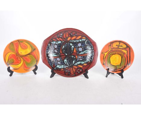 Three mid 20th Century Poole plaquesEach decorated in abstract shades of orange or red, the largest 35cm.