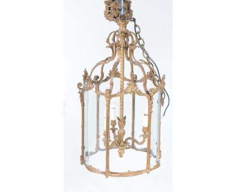 A 19th Century gilt metal and glazed pendant lantern light fitting Having a central spiralled shaft flanked by six leafy scro