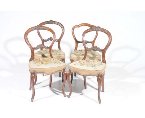 A set of three Victorian walnut balloon back dining chairs and a similar chairThe three chairs with a scrolling foliate crest