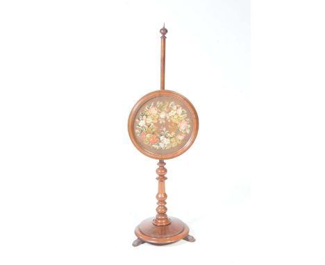 A mid 19th Century mahogany pole screenWith a spherical finial and a circular glazed floral needlework panel raised on a ring