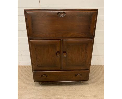 An Ercol bureau or cabinet 