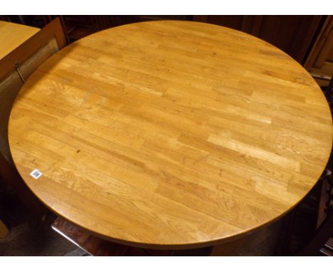 A 4' diameter light oak dining table 