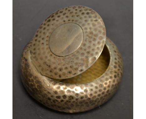An Arts and Crafts hammered circular snuff box, hinged cover, gilt interior, Henry Matthews, Birmingham 1900