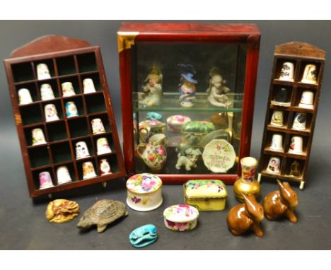 A curiosity glass front display cabinet containing miniatures including  Beswick rabbits , a Wade Disney Scamp whimsies ,cont