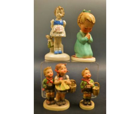 A Goebel Hummel figure , a child's prayer; to market, the village boy ;  a West German hand painted figure of a girl holding 