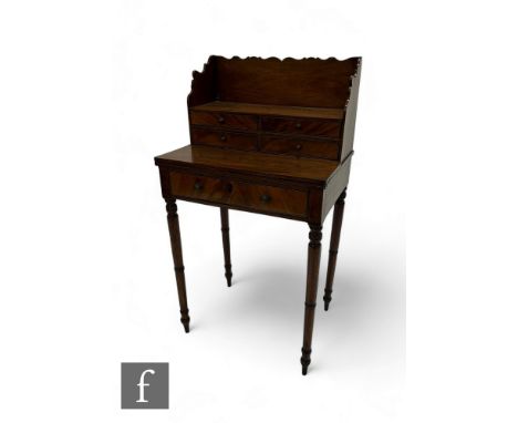 A small 19th Century George IV writing desk, the superstructure fitted with four short drawers over a hinged flap and a deep 
