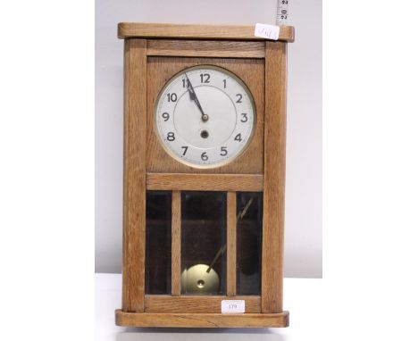 A vintage oak cased wall clock. No key a/f. Shipping unavailable. 
