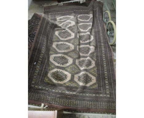 A machine woven Bokhara rug with two columns of six elephant gulls on a light brown ground, multi guard borders, tasselled en