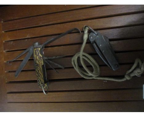 A horn clad multi-tool pocket knife, and another pocket knife on rope lanyard Location: 