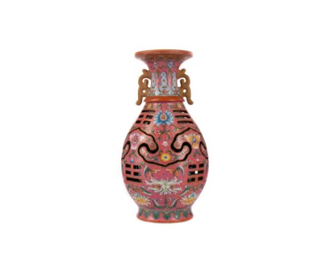 CHINESE REVOLVING VASE, twin-handled, the outer body finely painted in enamels with lotus sprays against a coral ground incis