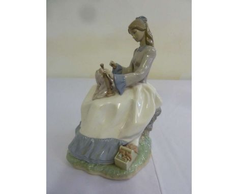 Nao figurine of a girl seated sewing