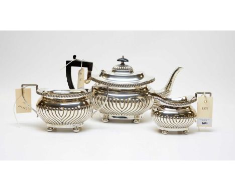 An Edwardian three-piece silver tea service, by Joseph Gloster Ltd, Birmingham, 1909, of Georgian shape, with half gadrooned 
