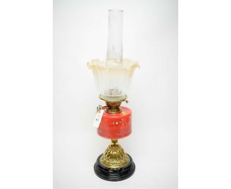 Brass oil lamp, with gilt decorated red glass reservoir, glass funnel and opaque glass shade, on stepped circular base, 65cms