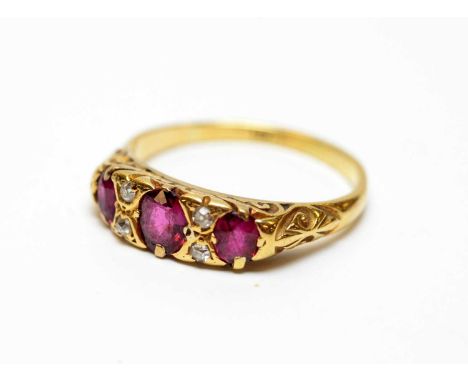 A three-stone ruby and diamond dress ring, on high carat yellow-metal, stamped 18ct, 3.2g, size O.