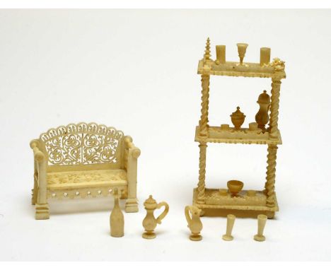 19th Century carved ivory miniatures, including a what-not with a display of teacups, cups, and vessels, and a reticulated ga