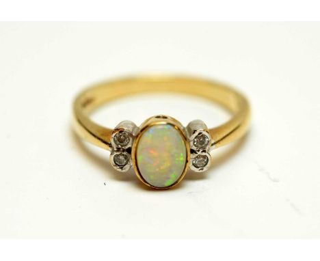 An opal and diamond ring, the oval opal flanked by pairs of diamonds, on 9ct yellow gold shank, ring size M, 2.8g.